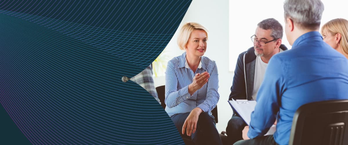 Blond mature woman sharing issues during meeting.