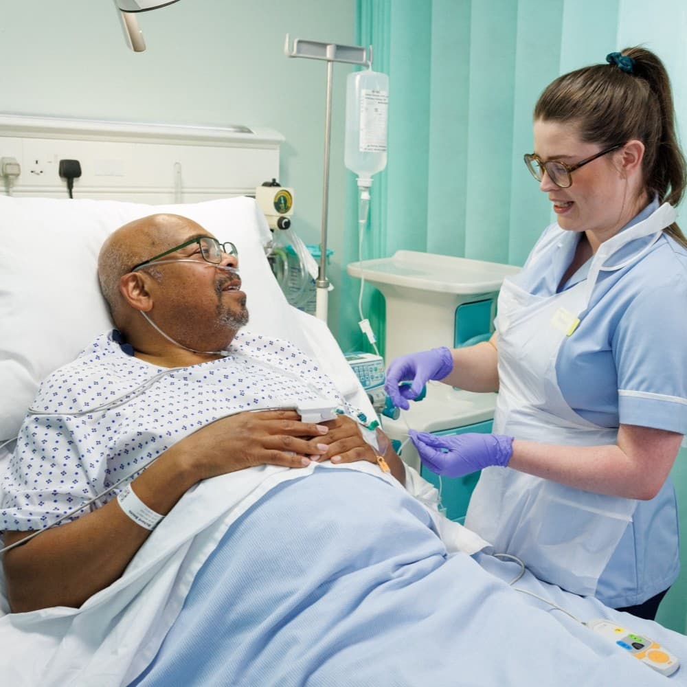 Hospital nurse talking to a patient.